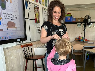 Leesconsulent Yvette Janse geeft aan Luus van Vuuren de boekenbon die ze heeft gewonnen.